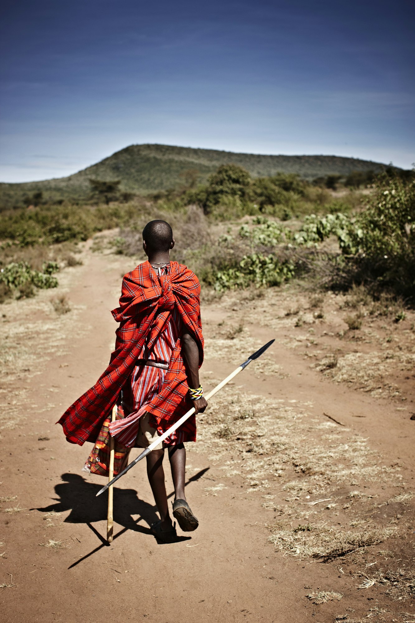 Maasai man walking on dirt road